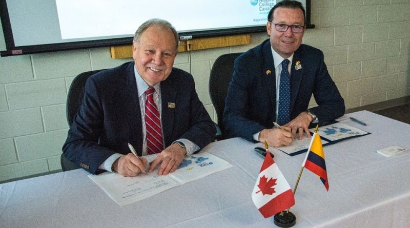 Dan Patterson y Omar Lengerke firmando acuerdo de cooperación
